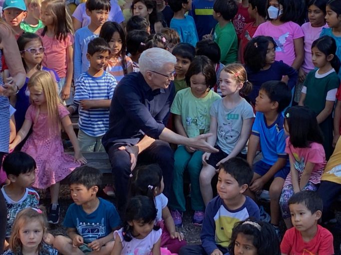 Anderson Cooper of 60 Minutes greets the Khan Lab School students next to him.